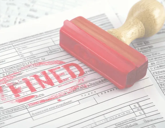Wooden-handled rubber stamp resting on a tax form stamped in red with the word 'Filed'