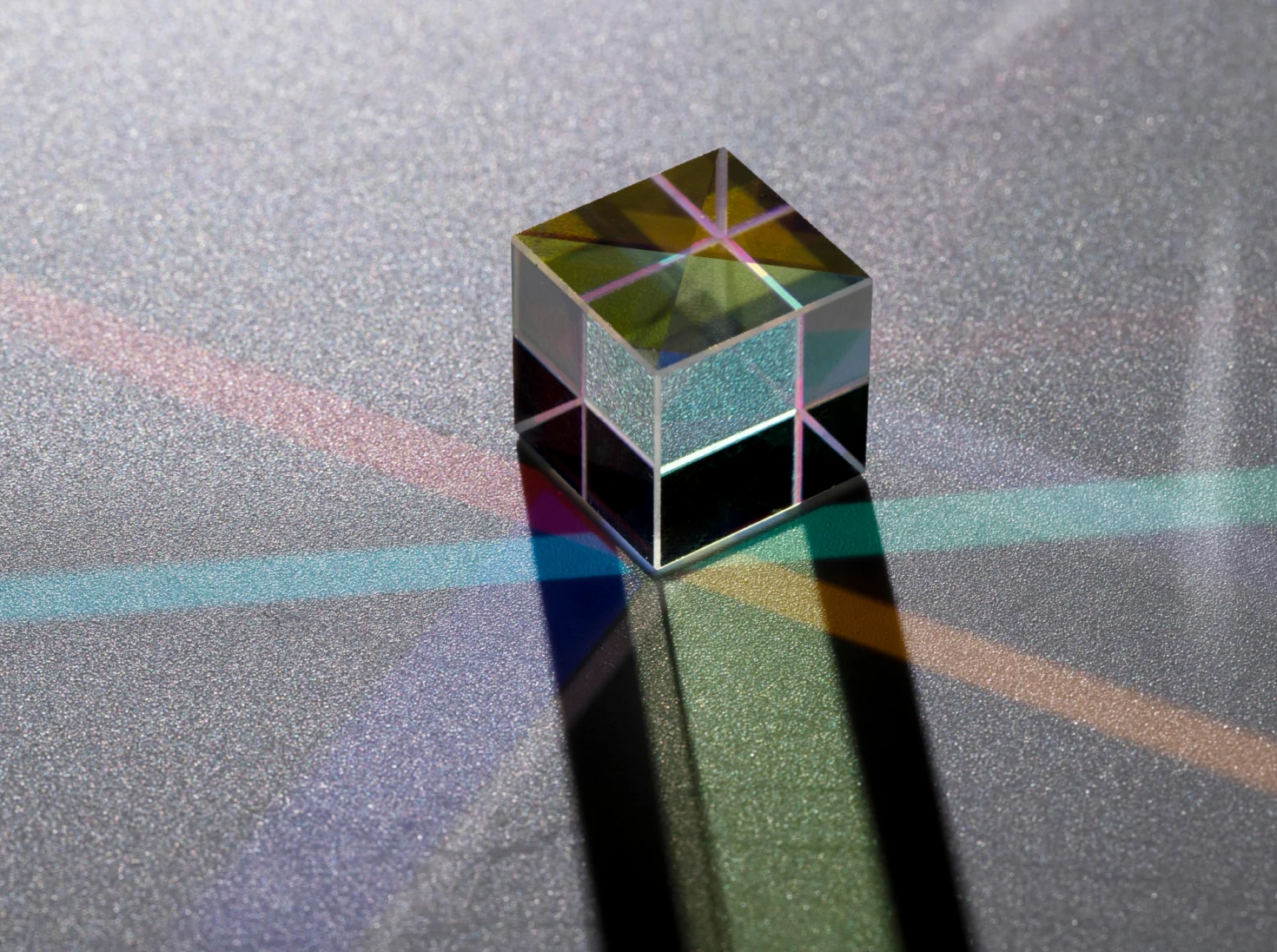 Glass prism cube splitting light into colours